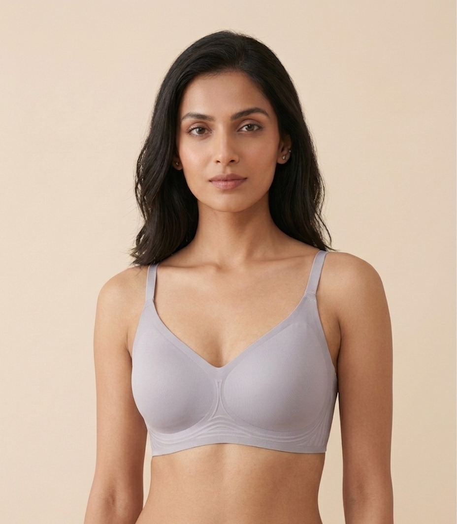 Woman wearing a light gray bra against a beige background