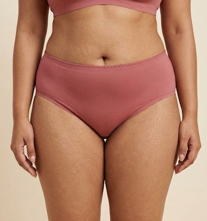 Person wearing a pair of pink high-waisted bikini bottoms on a beige background